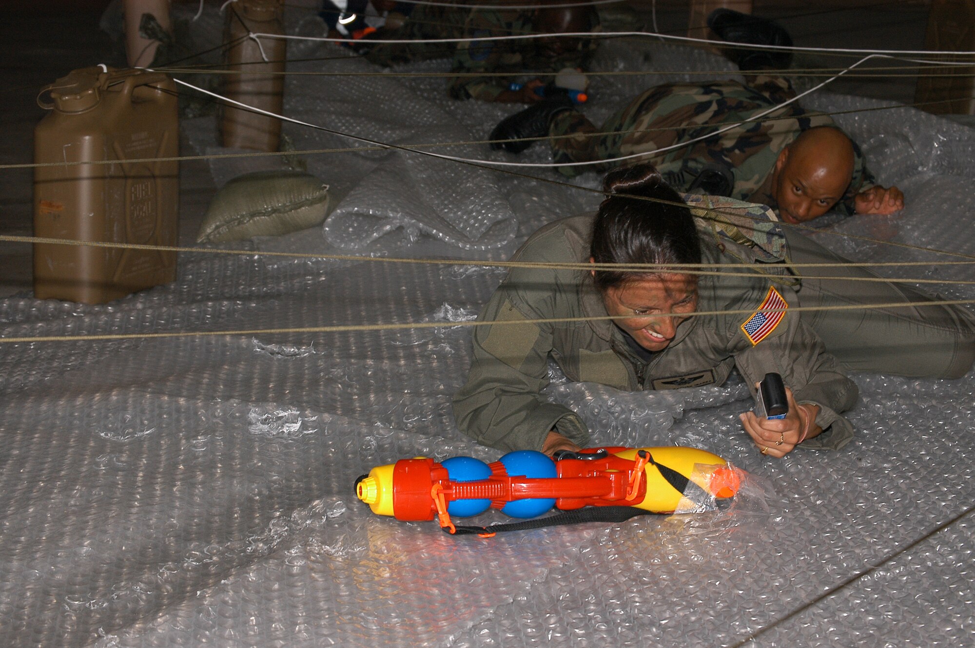 Master Sgt. Carmen Ibarra from Detachment 3, 25th Intelligence Squadron, concentrates on her low crawl as she nears the end of the obstacle course leading to the 353rd Special Operations Group Combat Dining Out.                               