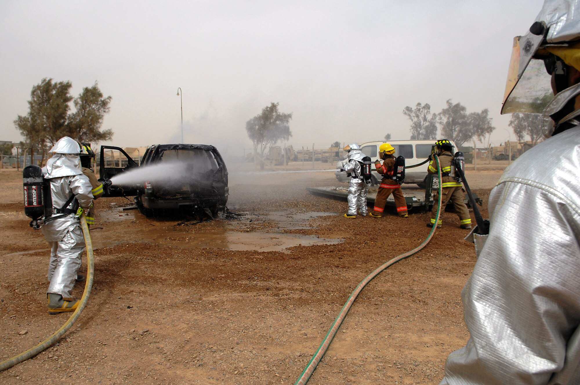 Firefighters from the 332nd Expeditionary Civil Engineer Squadron and 8th Ordnance Company put out a vehicle fire during vehicle extrication training April 5 at Balad Air Base, Iraq. During the training, Army and Air Force firefighters honed their abilities to rescue people trapped in vehicles and other confined spaces. Working jointly allows the firefighters to coordinate their efforts when responding to emergency situations. (U.S. Air Force photo/Senior Airman Julianne Showalter) 
