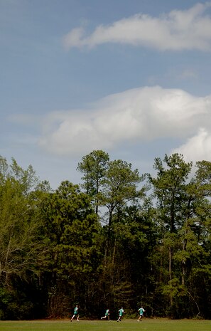 Members from the 437th Maintenance Group run along the tree line during the Commander's Fitness Challenge April 4. (U.S. Air Force photo/Senior Airman Nicholas Pilch)