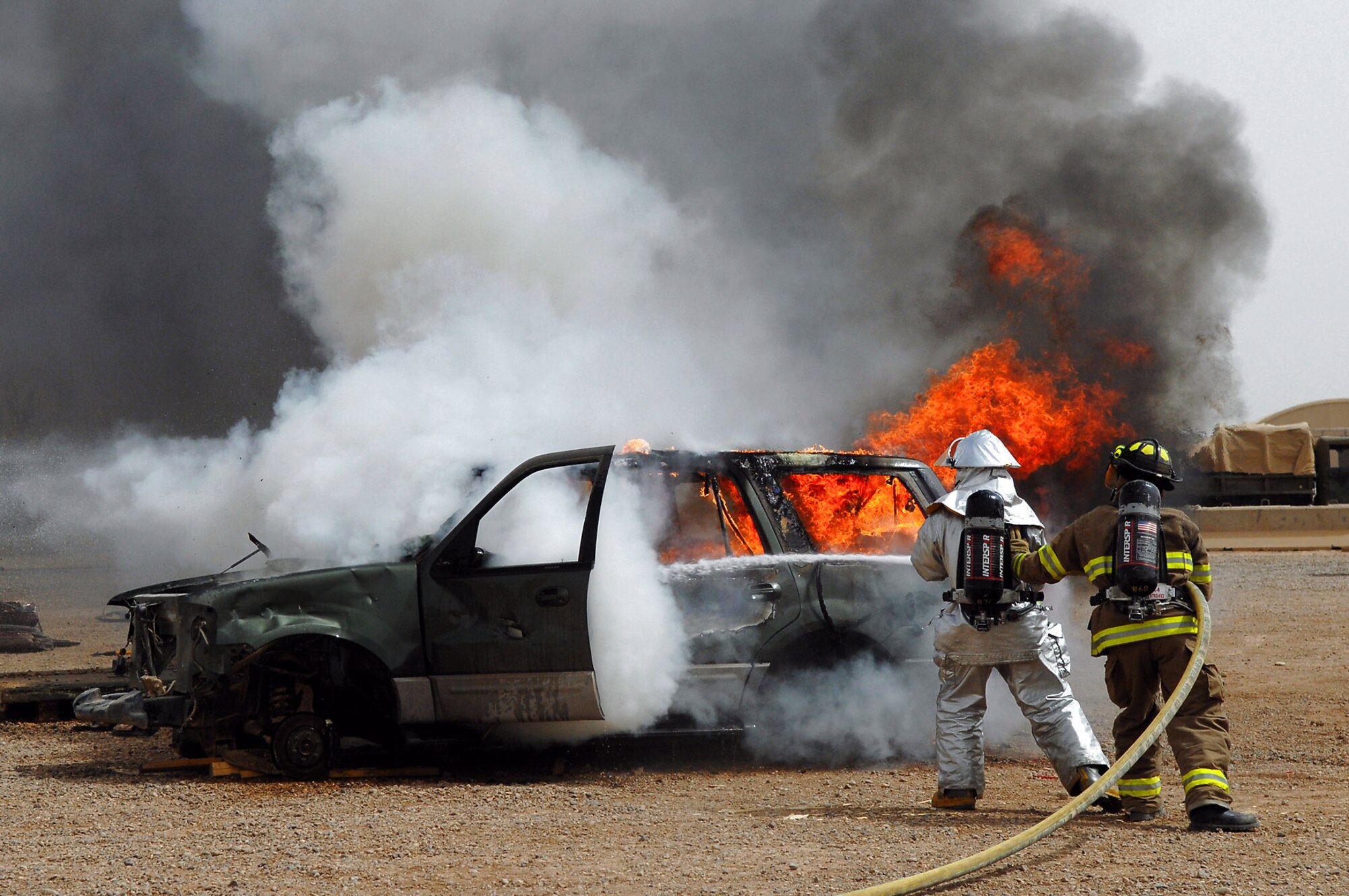 Firefighters from the 332nd Expeditionary Civil Engineer Squadron and 8th Ordnance Company put out a vehicle fire during vehicle extrication training April 5 at Balad Air Base, Iraq. During the training, Army and Air Force firefighters honed their abilities to rescue people trapped in vehicles and other confined spaces. Working jointly allows the firefighters to coordinate their efforts when responding to emergency situations. (U.S. Air Force photo/Senior Airman Julianne Showalter) 
