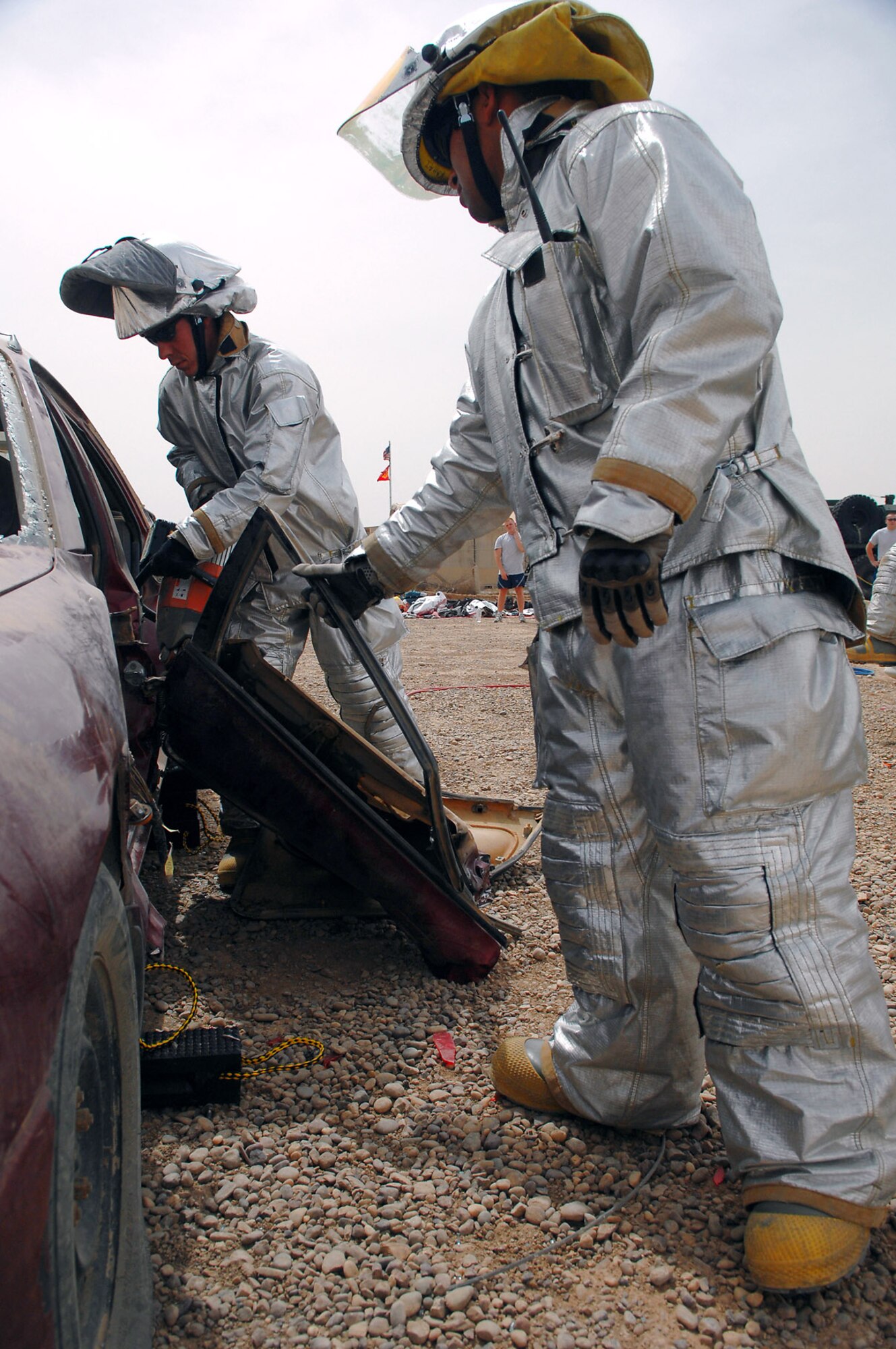 Staff Sgt. Michael Reece and Airman 1st Class Matthew Kahai cut a door off a car during vehicle extrication training April 5 at Balad Air Base, Iraq. Extrication training teaches firefighters how to rescue people trapped in vehicles. Sergeant Reece is a reservist from Seymour Johnson Air Force Base, N.C., and Airman Kahai is deployed from Minot AFB, N.D. Both are 332nd Expeditionary Civil Engineer Squadron firefighters. (U.S. Air Force photo/Senior Airman Julianne Showalter) 

