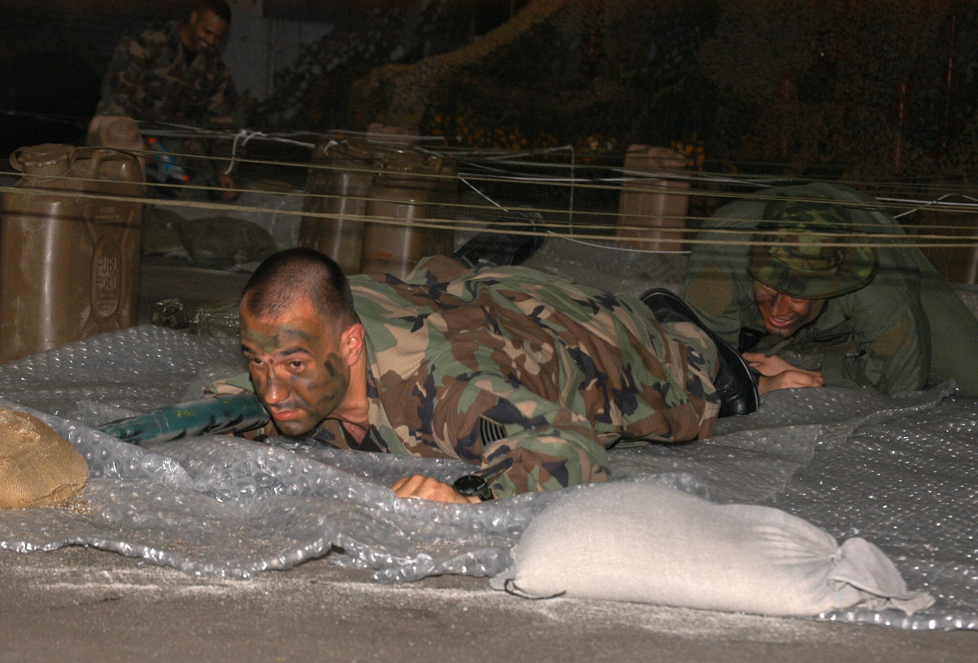Tech. Sgt. Vincent Juarez, Det. 3, 25th Intelligence Squadron, low crawls through an obstacle course during the 353d Special Operations Group Combat Dining Out April 4. (U.S. Air Force photo/Master Sgt. Marilyn Holliday)         