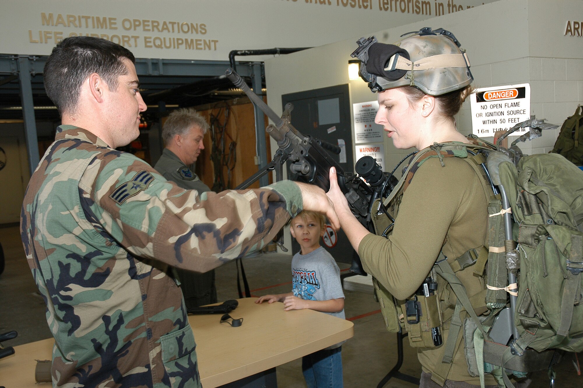 Joleen Baker takes a closer look at an M-249 Squad Automatic Weapon, with help from Senior Airman Jeremy King from the 320th Special Tactics Squadron during the Air Commando Spouses Day at the 353rd Special Operations Group April 4. (U.S. Air Force photo/Master Sgt. Marilyn Holliday)