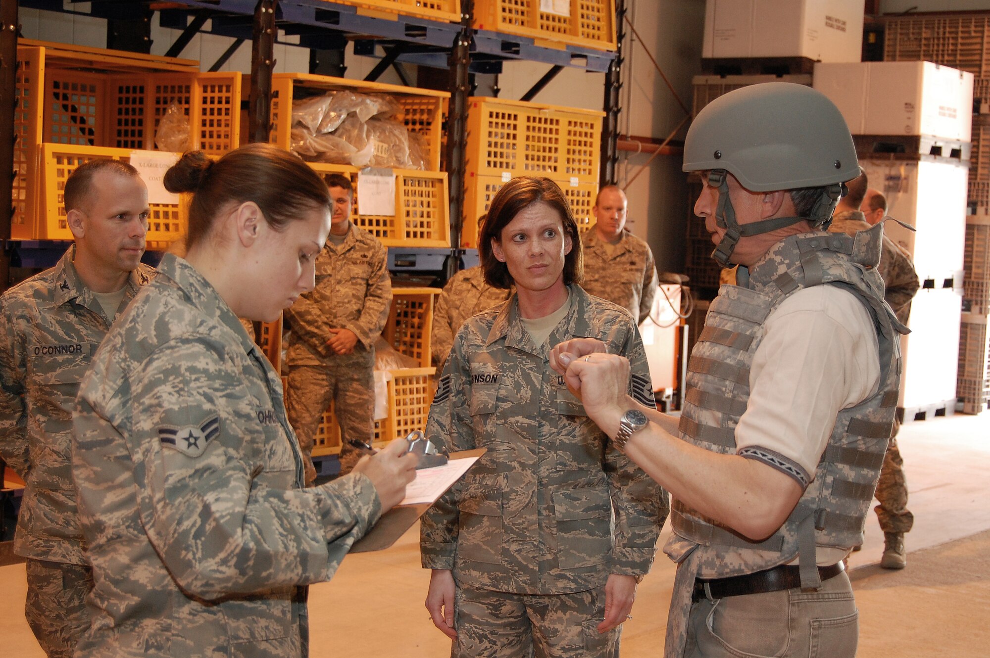 SOUTHWEST ASIA -- The Honorable Craig Duehring, the Assistant Secretary of the Air Force for Manpower and Reserve Affairs, Washington, D.C., talks with Airmen from the 386th Expeditionary Logistics Readiness Squadron's Expeditionary Theater Distribution Center at an air base in the Persian Gulf Region recently. Tech. Sgt. Eugenia Robinson, (center), briefed Mr. Duehring about the ETDC and it being one one of three in the deployed area of responsibility prior to outfitting him, Brig. Gen. William Busby, and Col. Anne Hamilton, with their personal protective gear for their pending trip throughout the deployed theater. The purpose of their visits is to gain insight on manpower, morale, and Reserve affairs issues affecting today’s Airmen and much more. (Air Force photo/Tech. Sgt. Michael O'Connor)
