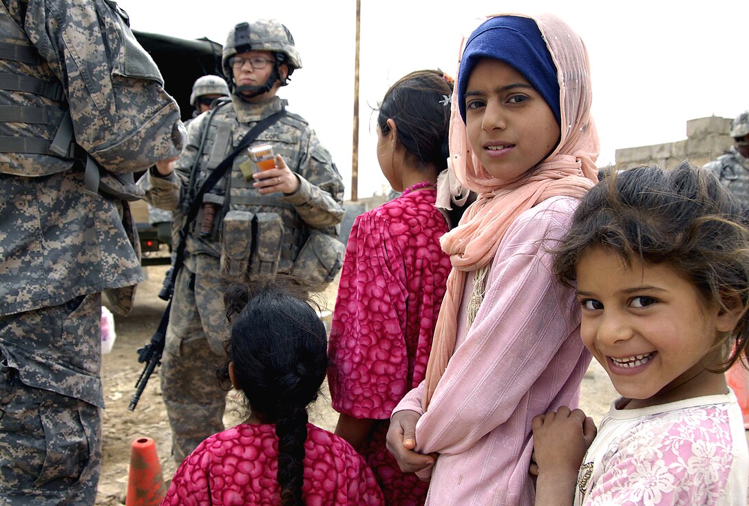 Iraqi girls wait in line to receive medical aid and school supplies from U.S. soldiers in Sabah Nissan, Iraq, March 27, 2008. The soldiers are assigned to the 3rd Infantry Division's 1st Battalion, 10th Field Artillery Regiment.