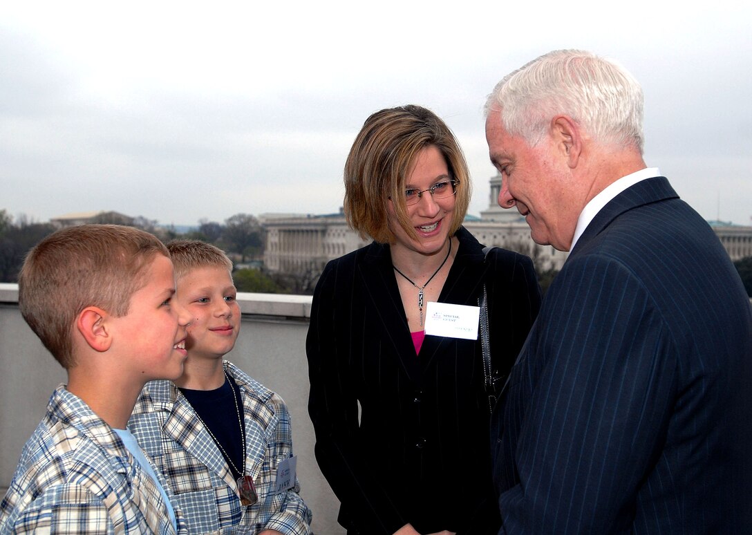 Defense Secretary Robert M. Gates talks with Will Bacon (left front), 10,  his brother, Jake, 9, and their mother, Christine, during an "Our Military Kids" reception to honor military children. The boys' father, Missouri National Guardsman Maj. Matt Bacon, is deployed to Iraq. 