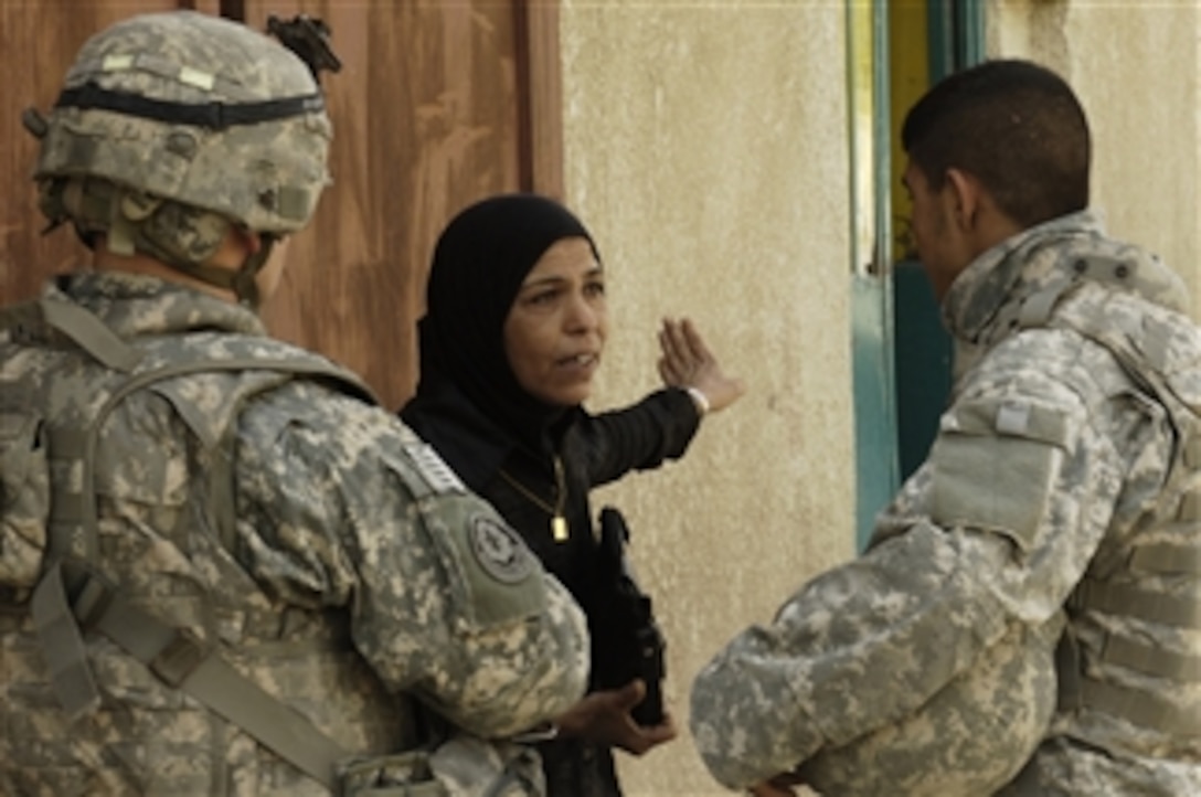 A U.S. Army soldier and an Iraqi interpreter talk to an Iraqi woman during a patrol in Amiriyah, Iraq, on April 4, 2008.  Soldiers from Charlie Troop, 4th Battalion, 10th Cavalry Regiment, 2nd Brigade Combat Team, 4th Infantry Division are in the area to seek information from family members of detainees and to assess security checkpoints. 