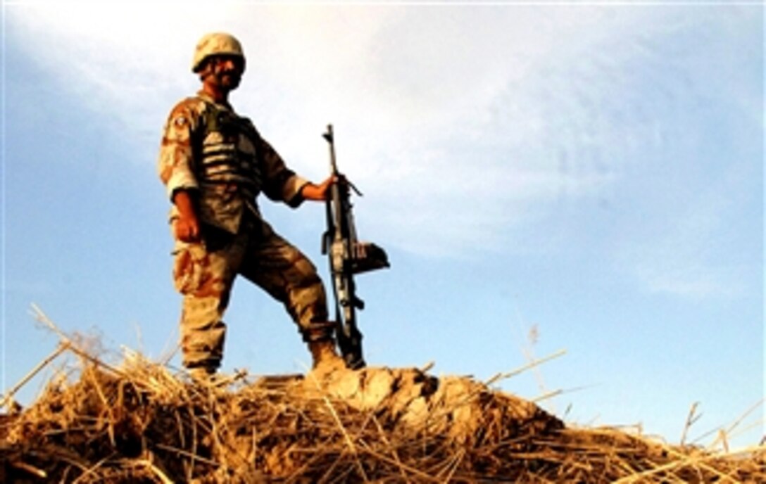 An Iraqi soldier stands on top of a hill as he scouts ahead during a mission with U.S. soldiers in Mahmudiyah, Iraq, April 1, 2008. 