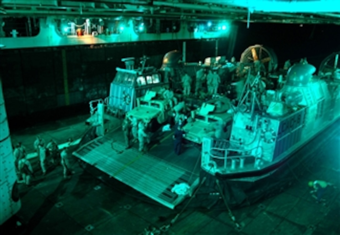 Sailors and Marines load equipment onto a landing craft air cushion in the well deck of the amphibious assault ship USS Tarawa in the U.S. 5th Fleet area of responsibility, March 29, 2008. 
