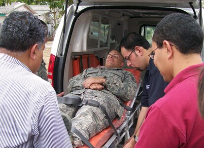 SOTO CANO AIR BASE-- Air Force Staff Sgt. Tom Murray, Joint Task Force-Bravo medical technician, is strapped to a gurney while Honduran emergency medical professionals practice proper loading and unloading procedures in a new ambulance which will be put into use at Hospital Escuela, Tegucigalpa, Honduras. JTF-Bravo's personnel were available for an information exchanges with Honduran medical professionals seeking an understanding of American emergency protocol that may assist the Hondurans with creating their own standardized emergency guidelines.
