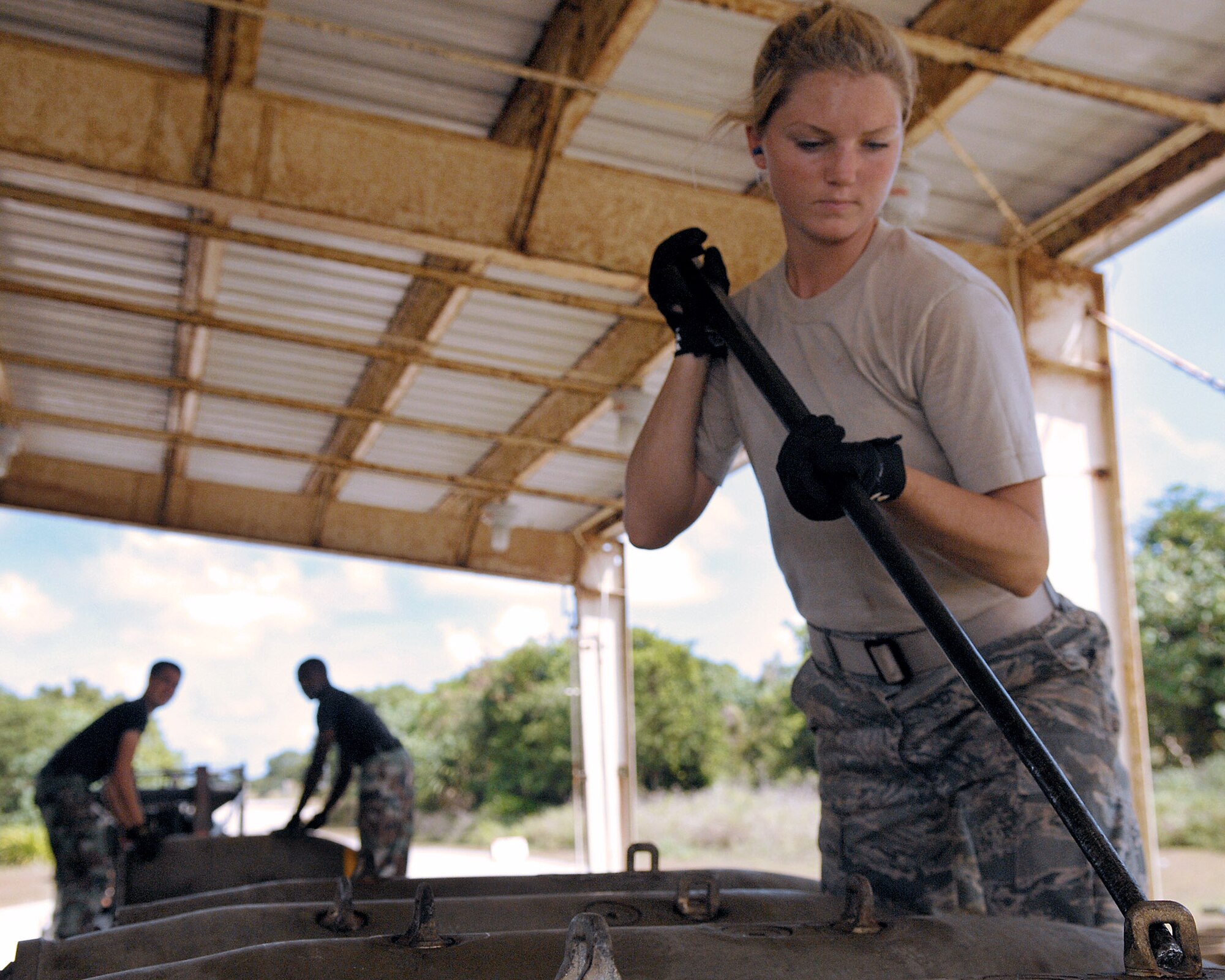 Airman First Class Casey Carrano loads several bombs on a truck. Airmen Carrano and the other munitions specialists in the 36th Munitions Squadron at Andersen Air Force Base, Guam, are assembling free-fall, unguided, general purpose 750-pound bombs that will eventually be loaded on a B-52 Stratofortress. In a conventional conflict, the B-52 can carry nuclear or precision-guided conventional ordnance with worldwide precision navigation capability.  (U.S. Air Force photo/Staff Sgt. Vanessa Valentine)