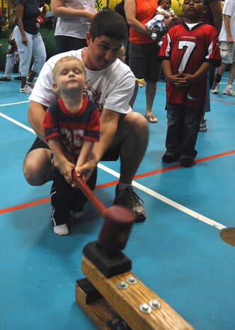 Nate Peterson and his father, Senior Airman Ben Peterson, enjoy a traditional carnival game together at the Month of the Military Child Festival Saturday. Nate is the one-year-old son of Airman Peterson who is with the 437th Force Support Squadron. (U.S. Air Force photo/Airman 1st Class Timothy Taylor)