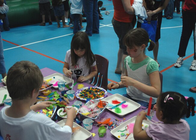 Children from the Charleston AFB community enjoy making custom pieces of art at the arts and crafts table during the Month of the Military Child Festival held at the Child Development Center Saturday. Aside from arts and crafts, there were many other activities set up by the CDC's volunteers for young children to enjoy. (U.S. Air Force photo/Airman 1st Class Timothy Taylor)