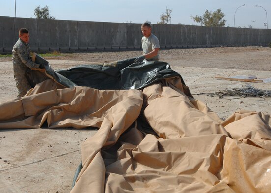 Senior Airman Lewis Paine, 332nd Expeditionary Civil Engineer Squadron power production journeyman and Senior Airman Ivan Alandzak, 332 ECES liquid fuel journeyman, prepare a portion of a tent that used to be part of the Air Force Theater Hospital here, Feb. 29. The tent was shipped April 1 to the National Museum of Health and Medicine in Washington, D.C., where it is slated for exhibition because it is known, by the medical community, as the place where the most American blood was spilled since the Vietnam War. Airman Paine is deployed from Ellsworth, S.D., and Airman Alandzak is deployed from Malmstrom Air Force Base, Mont. (U.S. Air Force photo/ Senior Airman Julianne Showalter)