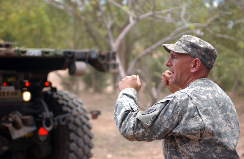 LAS MESAS, Honduras - Army National Guard Sgt. James M. McDonough of the 1430th Engineer Company ground-guides a vehicle to work on property surrounding the grade school of this rural village. Soldiers from the 672nd, 756th, and 1430th Engineer Companies are working in Las Mesas during the joint forces training exercise Beyond the Horizon. They will replace the school's doors and windows, repair the roof, and repaint the entire structure, in addition to improving a soccer field on which local children play. Beyond the Horizon provides infrastructure renovation, as well as basic medical and dental care, to areas across this Central American country. (Photo by Sgt. Claude W. Flowers, 304th Public Affairs Detachment.)