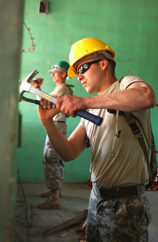 LAS MESAS, Honduras - Sgt. Juan M. Ozuna from the 672nd Engineer Company repairs a dilapidated schoolhouse during their Annual Training. U.S. Army engineers are among the personnel participating in Beyond the Horizon, a training exercise that provides infrastructure renovation, as well as basic medical and dental care, to rural areas of this Central American country. Soldiers working in Las Mesas will replace the school's doors and windows, repair the roof, and repaint the entire structure, in addition to improving a soccer field on which local children play. (Photo by Sgt. Claude W. Flowers, 304th Public Affairs Detachment.)