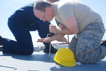 Senior Airman Christopher Snodderley and Technical Sgt. Shawn Connolly de-panel the t-tail of one of Westover's C-5's as part of the isochronical inspection process.