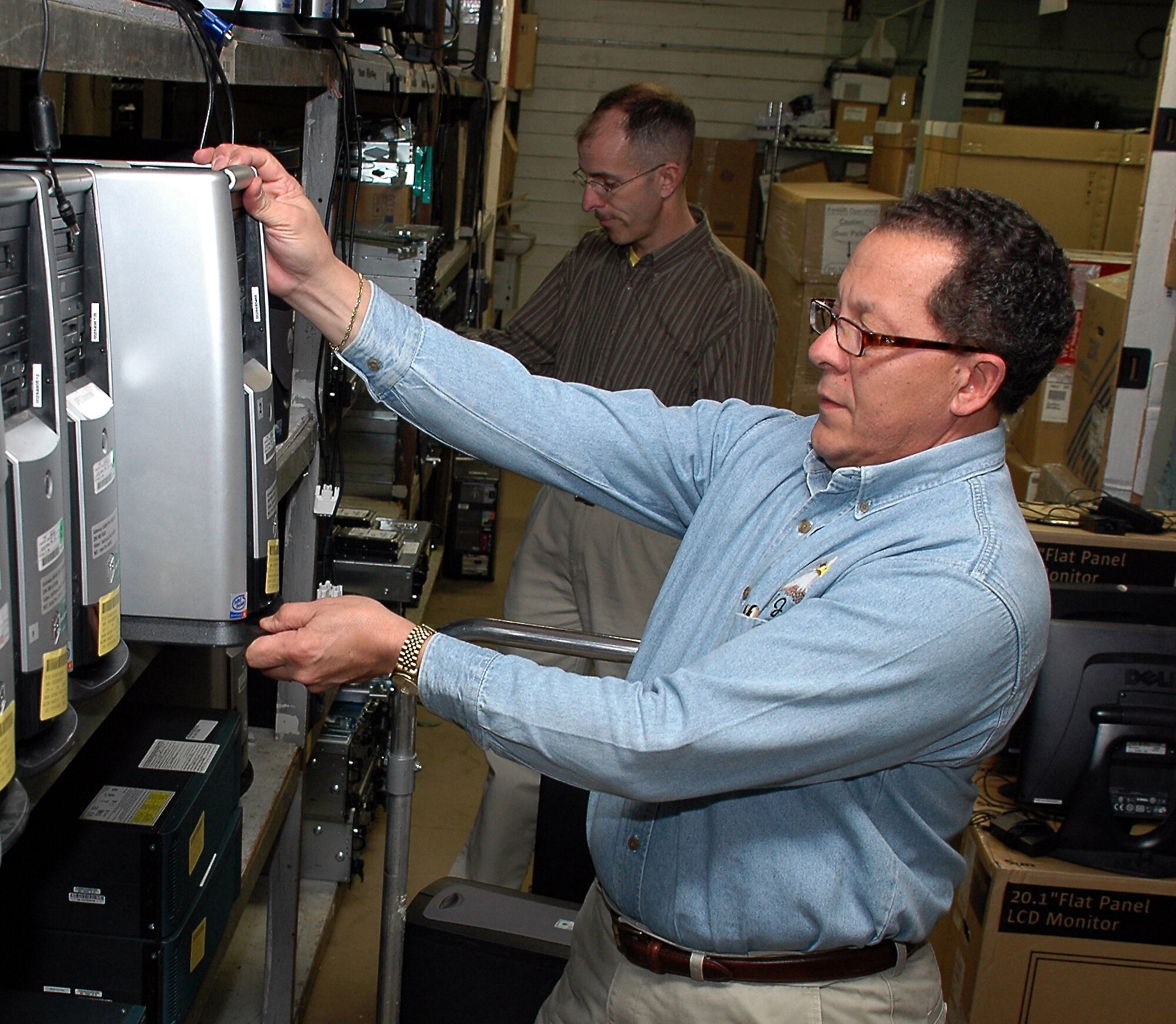 SCOTT AIR FORCE BASE, Ill. -- P.J. Torres  and Robert Montani, U.S. Transportation Command inventory control specialists, prepare computers for distribution to a local police agency as part of the command's technology refreshment program. (U.S. Air Force photo/Bob Fehringer)