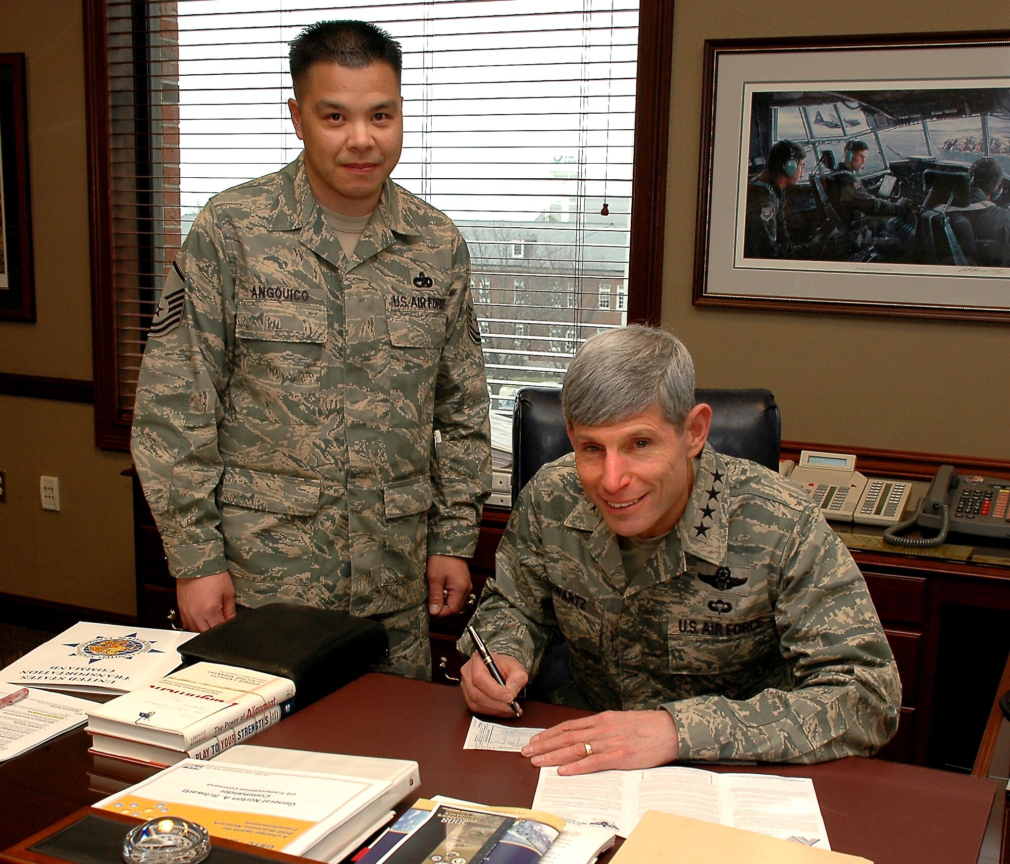 SCOTT AIR FORCE BASE, Ill. -- Master Sgt. Rodney Angquico, Air Force Assistance Fund key worker for the U.S. Transportation Command Support Group, stands by as Gen. Norton A. Schwartz, U.S. TRANSCOM commander, fills out his AFAF donation paperwork March 20.  (U.S. Air Force photo/Bob Fehringer)