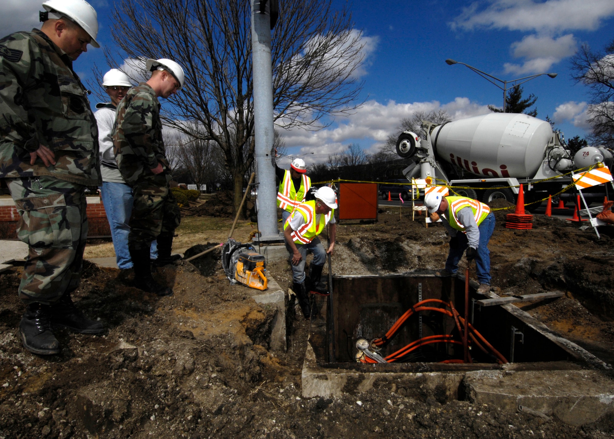 SCOTT AIR FORCE BASE, Ill. -- Tech. Sgt. Jeff Block and Airman Anthony Posey, 375th Communications Squadron voice network system maintainer technicians, watch over the civilian contractors as they work around fiber optic cables. The technicians make sure that their fiber optic cable, which carry valuable communications between headquarter buildings, are not damaged during the sidewalk construction. (U.S. Air Force photo/ Senior Airman Mildred Guevara)