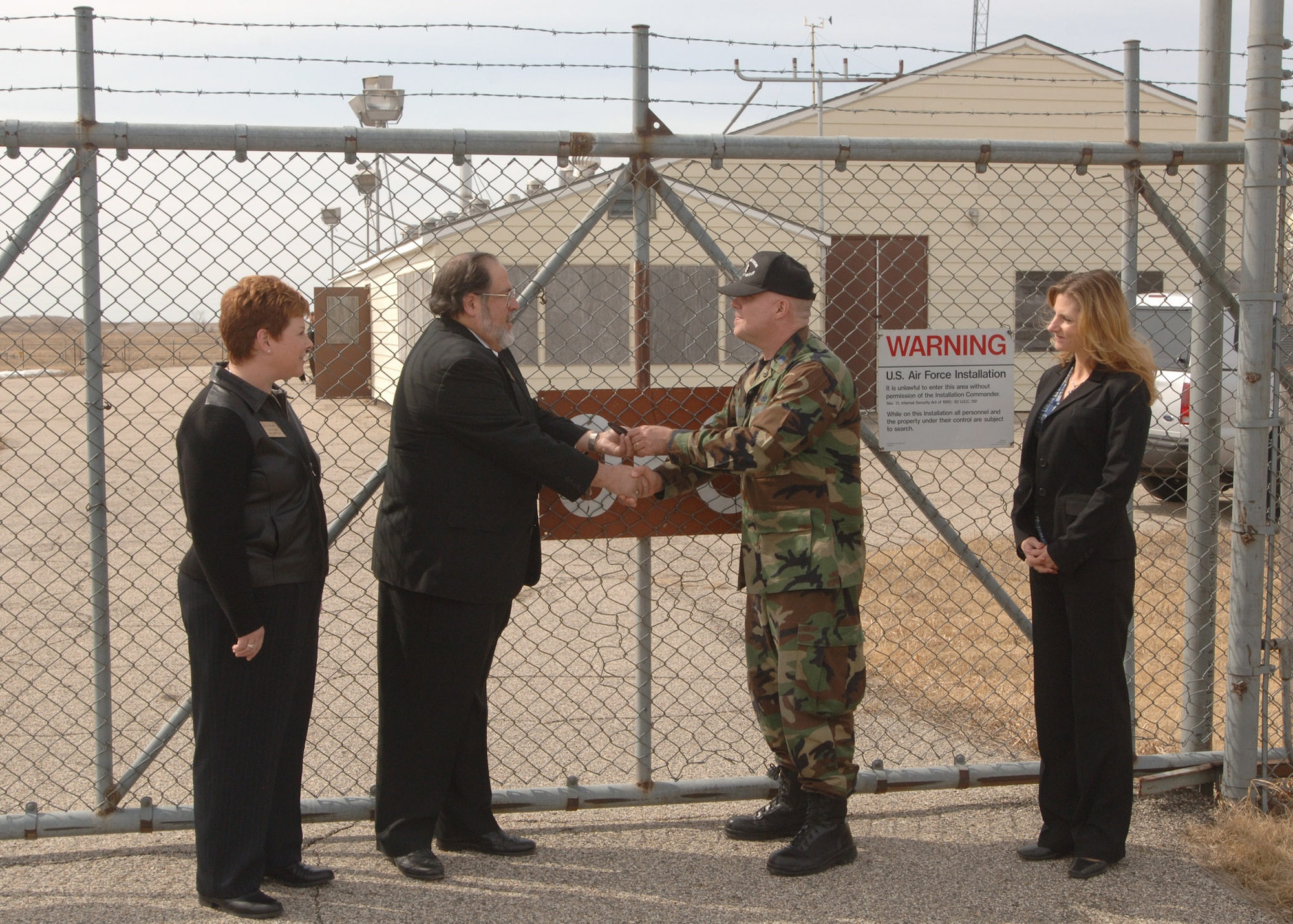 GRAND FORKS AIR FORCE BASE, N.D. – Lt. Col. Kurt Searfoss, 319th Mission Support Group Deputy Comamnder, hands over the keys to Oscar Zero intercontinental ballistic missile launch facility to Dr. Albert Berger, State Historical Society of North Dakota president, during a ceremony April 8 near Cooperstown, N.D. The ceremony marks the transfer of the site and the November 33 missile silo from the Department of the Air Force to the state in order to turn it into a historical site open to the public. (U.S. Air Force photo/Senior Airman Chad Kellum)