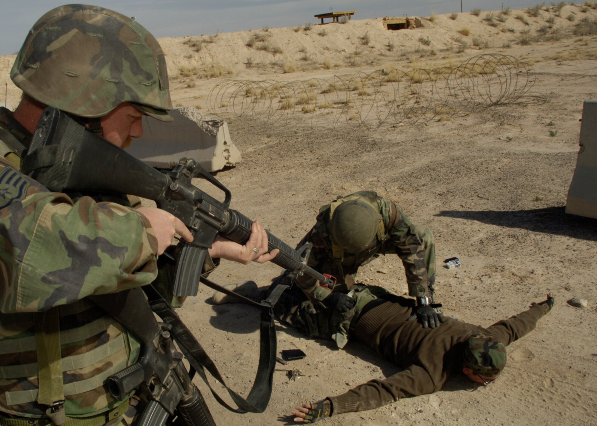 HOLLOMAN AIR FORCE BASE, N.M. -- Staff Sgt. Jason Able, 49th Civil Engineer Squadron, watches  as Airman 1st Class Lakeif Ferron, also from the 49 CES, searches a suspect played by Senior Airman Norman Luper, 49 CES, during the phase two exercise, Coronet Gold Rush 08-02, April 2. (U.S. Air Force photo/Airman 1st Class Michael J. Means)