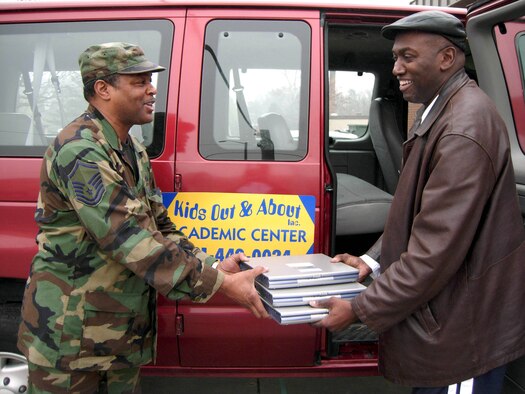 ANDREWS AIR FORCE BASE, Md. -- Master Sgt. Bernard Griggs, 459th Communications Flight, donates a few of 18 Micron GX3 laptops to Kids Out and About, a Temple Hills, Md., academic center, on behalf of the 459th Air Refueling Wing. Each year, the wing donates dozens of desktop and laptop computers and equipment to local schools and learning centers in need. Sergeant Griggs is the local area network non-commissioned officer for the 459th CF. Kids Out and About, Inc., run by owner/directors Melvin and Bennice Blount, tutors students ages 4-64, from grade school children to adults pursuing their doctorates. (U.S. Air Force photo/Staff Sgt. Amaani Lyle)
