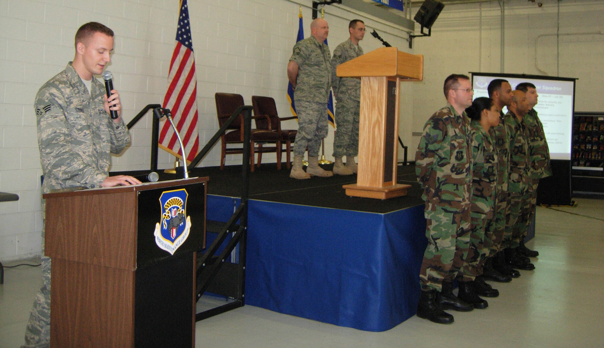 ANDREWS AIR FORCE BASE, Md. -- Senior Airman Patrick Stout, 69th Aerial Port Squadron transportation journeyman, as wing members stand on stage in Hangar 11 here April 6, during  "Tribute to Troops." The event was hosted by the 459th Mission Support Flight to thank returning troops for their various deployments during the last year. The event was emceed by Senior Airman Patrick Stout of the 69th Aerial Port Squadron. (U.S. Air Force photo/Staff Sgt. Amaani Lyle)