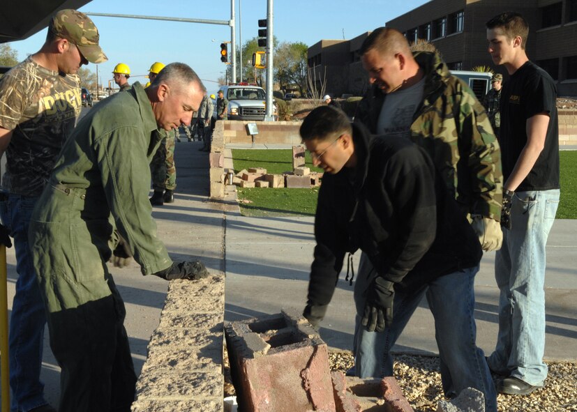 HOLLOMAN AIR FORCE BASE, N.M. -- Members of Team Holloman help tear down the brick wall surrounding Heritage Park here April 5. The wall was temporarily torn down to make room for the aircraft to enter the park. (U.S. Air Force photo by Airman Sondra M. Wieseler)