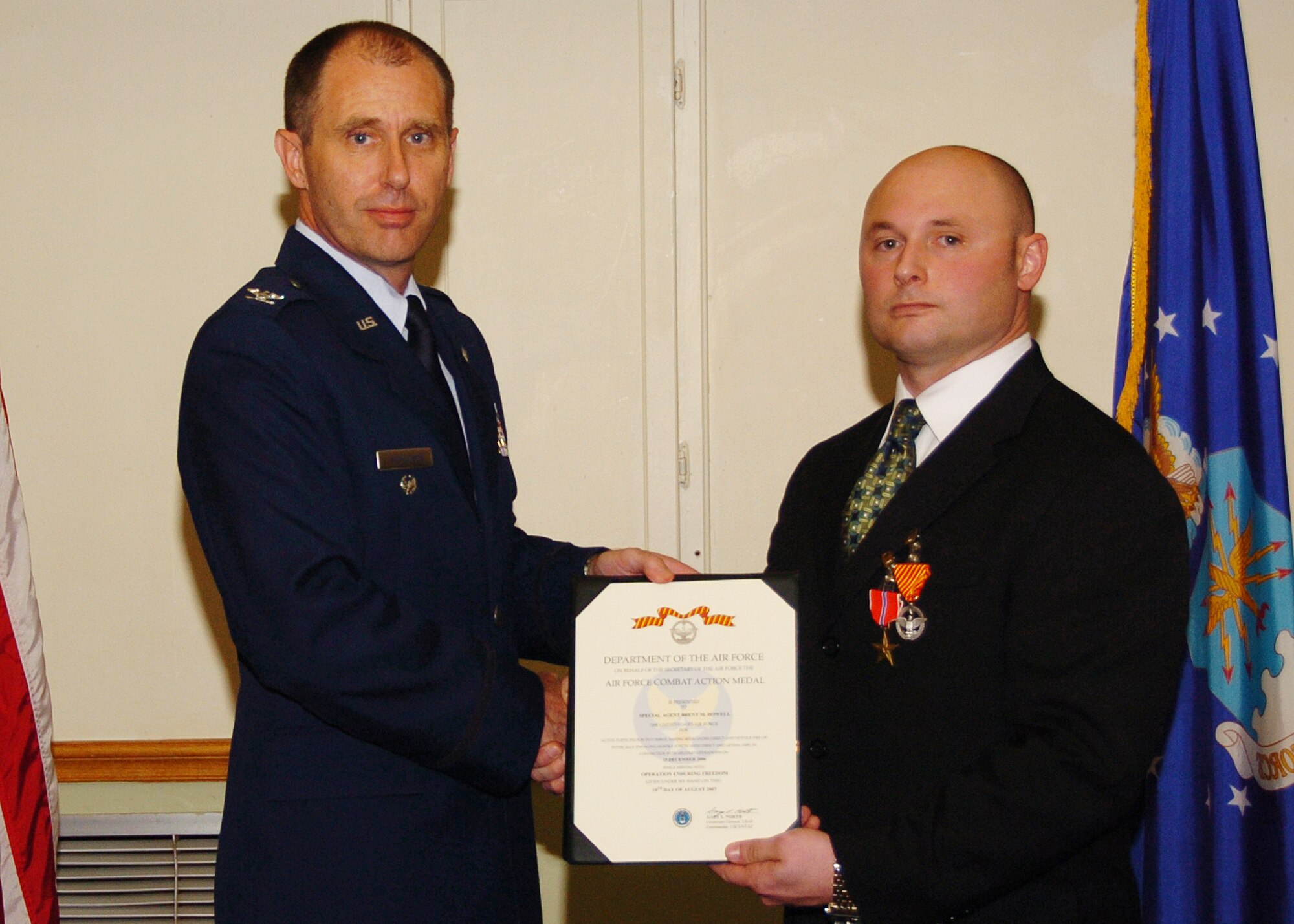 ALTUS AIR FORCE BASE, Okla. -- OSI Special Agent Brent M. Howell (right) was awarded the Bronze Star and the Air Force Combat Action Medal by Col. Michael Mendonca, 97th Air Mobility Wing vice commander, in a ceremony, Tuesday at Altus Air Force Base, Okla.  Special Agent Howell served seven months in Afghanistan where he lead more than 150 combat and intelligence missions and was wounded during an ambush. He was awarded the Purple Heart during his deployment in Afghanistan. (U.S. Air Force photo/Airman 1st Class Marianne Lane)