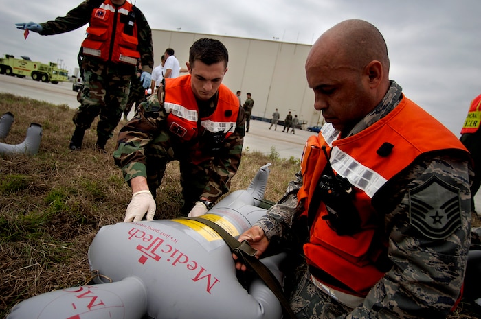 Master Sgt. Jose Pineiro and Airman 1st Class Joshua Jones place a medical mannequin on a stretcher during an exercise on the Charleston AFB flightline Tuesday. Sergeant Pineiro and Airman Jones are with the 437th Medical Group. (U.S. Air Force photo/Senior Airman Nicholas Pilch)