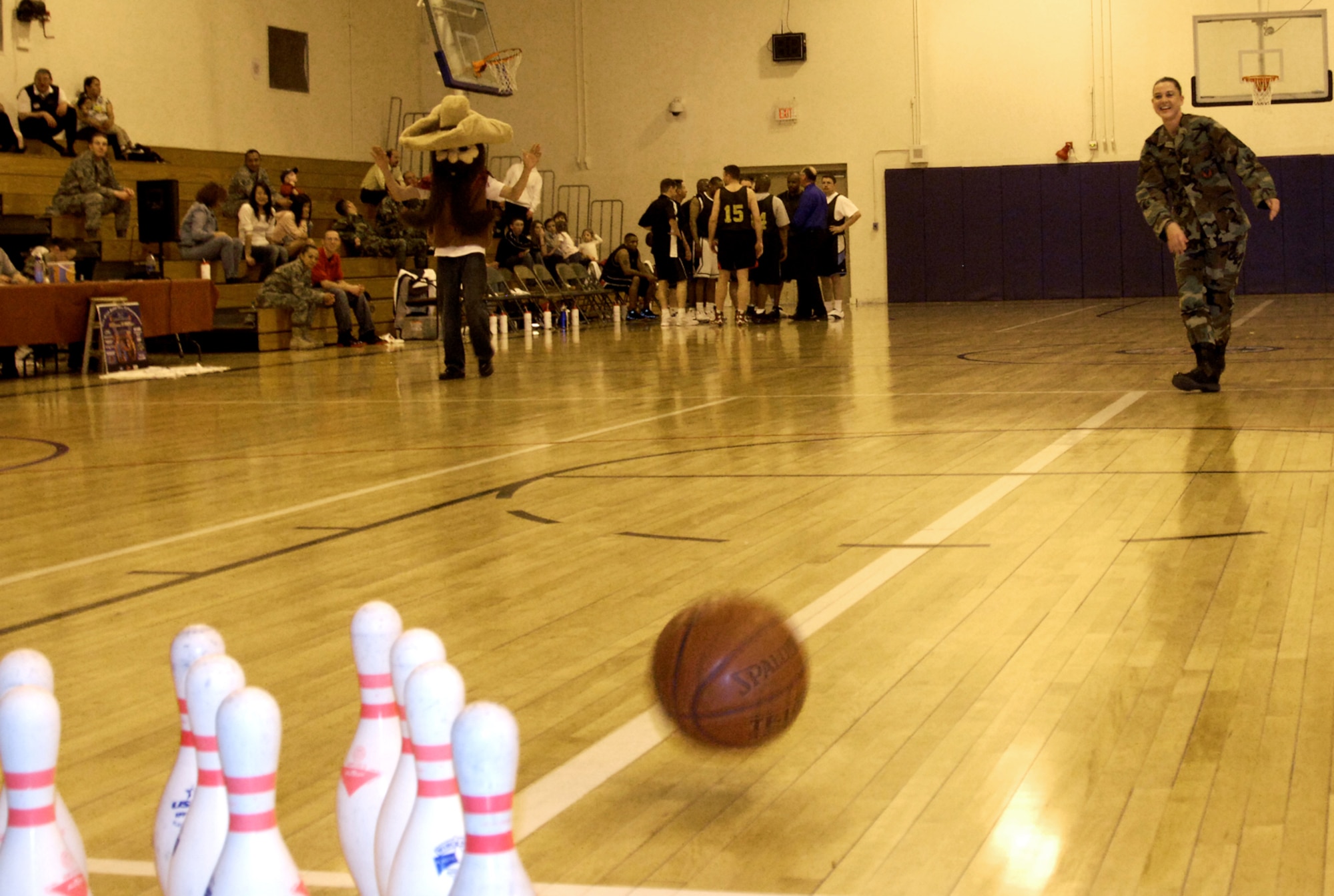 MOUNTAIN HOME AIR FORCE BASE, Idaho -- Senior Master Sgt. Jennifer Jones, 366th Comptroller Squadron first sergeant, rolls a basketball down the “lane” while trying to get a strike during a mini-game of bowling held between the quarters of the All-star basketball game. The All-star basketball game and extravaganza, held at the Gunfighter Fitness Center April 4, concluded the basketball season. Between the quarters and during half-time, free mini-games including bowling, hula-hoop and dizzy bat contests were held for audience members. (U.S. Air Force photo/ Senior Airman Megan P. Lyon)
