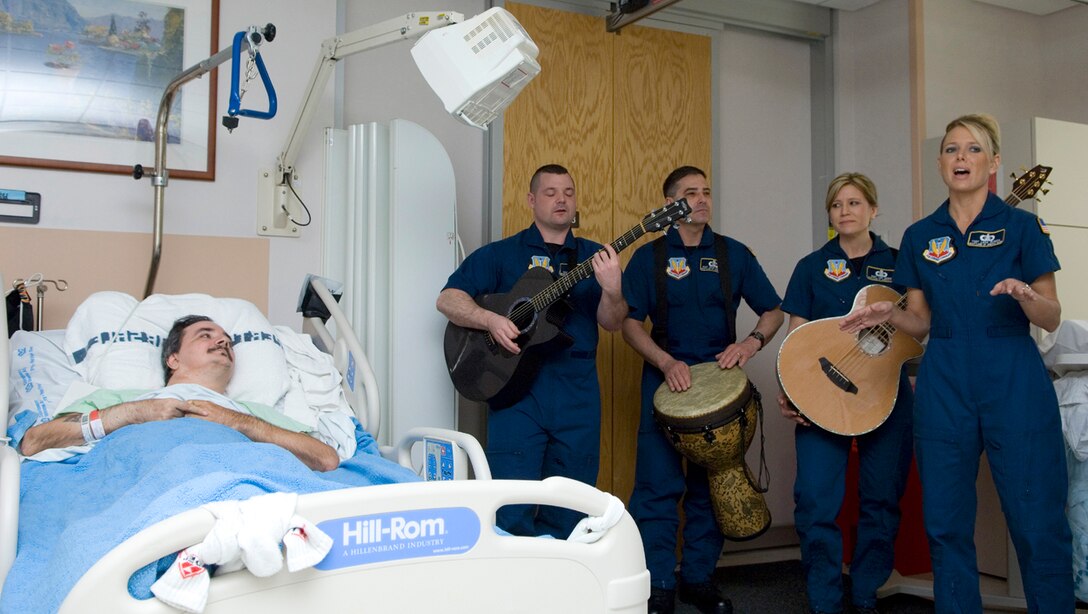 Members of the Air Force Heartland of America Band's Night Wing perform for a servicemember April 5 at the James A. Haley Veterans' Hospital in Tampa, Fla. The band performed throughout the hospital to lift the spirits of military members.  Night Wing is an ensemble of the Heartland of America Band stationed at Offutt Air Force Base, Neb. (U.S. Air Force photo/Staff Sgt. Bennie J. Davis III) 
