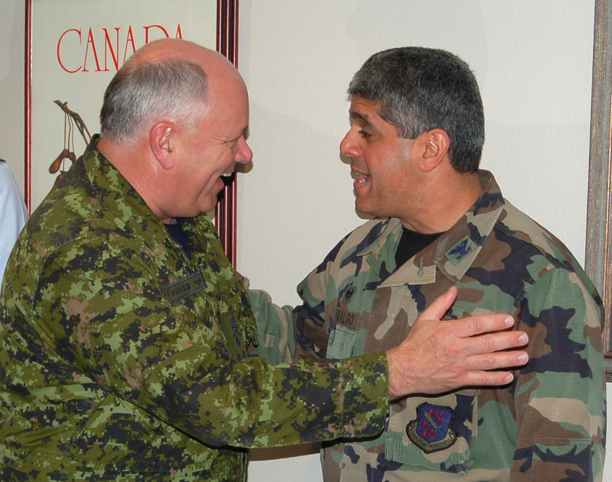 Lt. Gen. Charlie Bouchard, North American Aerospace Defense Command deputy commander, greets Col. Manny Hidalgo at the opening of the new Canadian Forces Support Unit offices April 1. The 21st Space Wing used roughly $500,000 to fund the new offices, which will house the Canadians’ personnel support services and computer networks. Colonel Hidalgo is the 21st Mission Support Group commander. (U.S. Air Force photo/Corey Dahl)