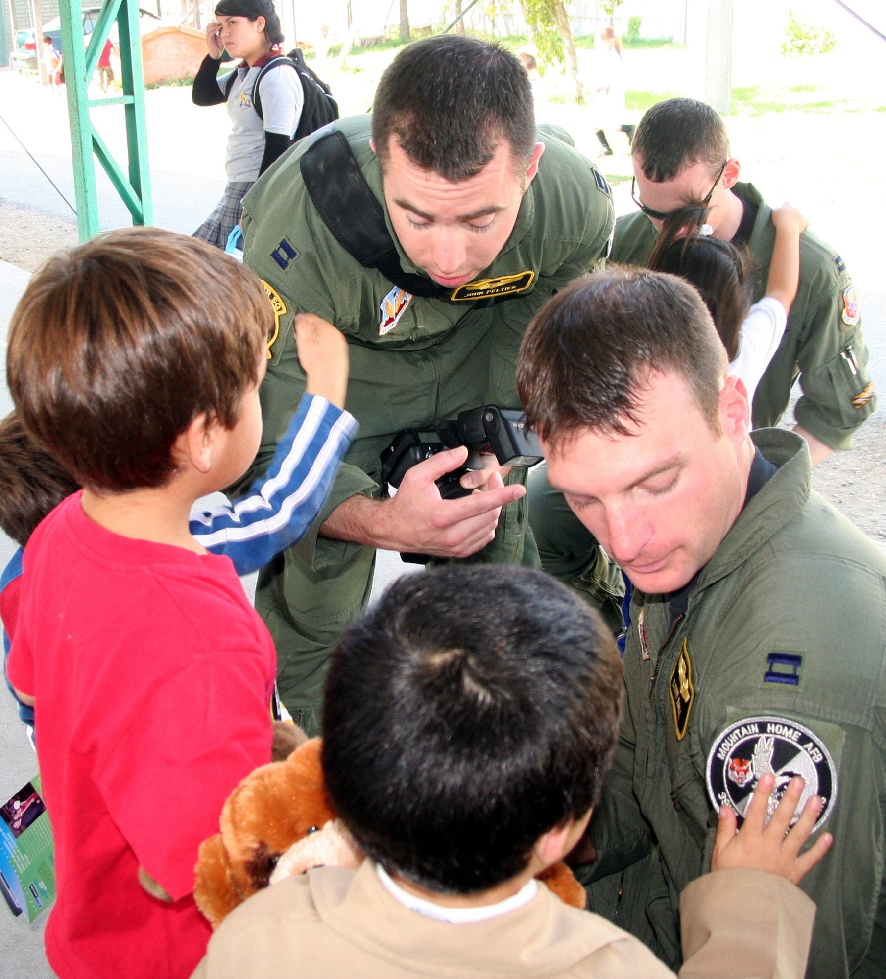 SANTIAGO, Chile – Capts. John Peltier and Luke Ball, 391st Fighter Squadron, show off their squadron patches to Chilean orphans April 3. The captains are here in support of the largest South American airshow, FIDAE, where they are showcasing F-15E aircraft to international audiences.  (U.S Air Force photo by/1st Lt. Candace Cutrufo)