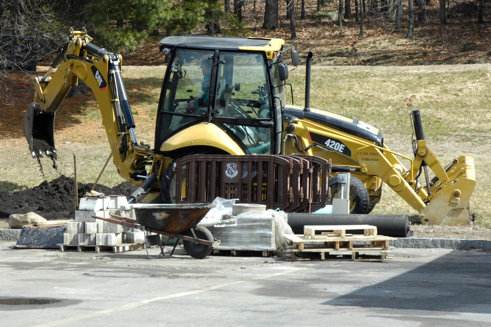 David Little, Civil Engineering Heavy Equipment operator, uses a backhoe near the Motor Pool’s entrance to begin construction on a water quality swale. The swale, which was completed in late March, collects excess rain water and allows it to drain slowly -- reducing flooding on base and into the Shawsheen River. Cattails have been planted along the swale’s slopes to absorb pollutants in and improve the quality of the collected water that eventually drains into the river or seeps into the ground.  (U.S. Air Force photo by Linda LaBonte Britt)