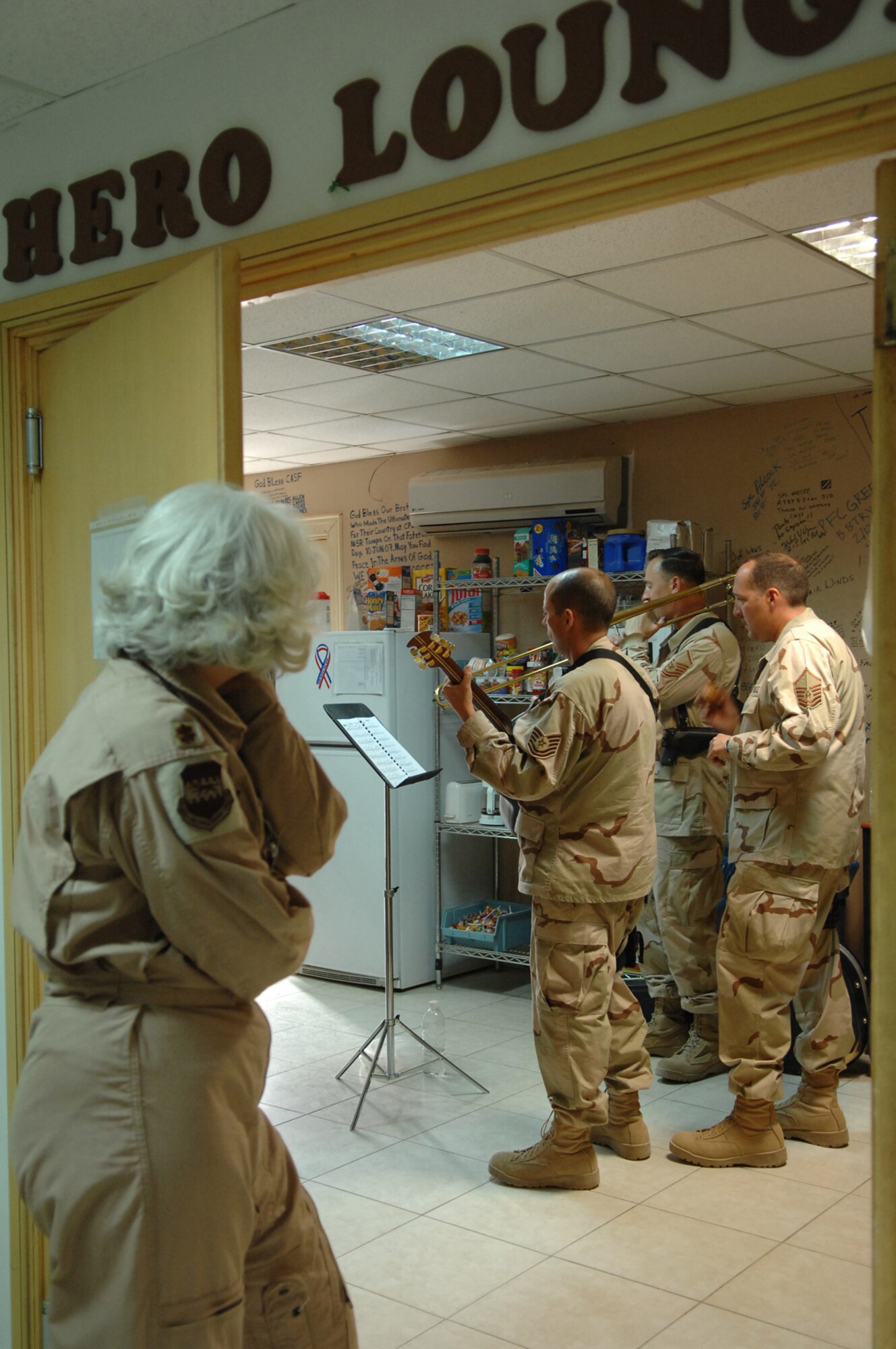 BALAD AIR BASE, Iraq -- Maj. Melinda Screws, 332nd Expeditionary Aeromedical Squadron flight nurse, listens in as three members of Hot Brass play at the Contingency Aeromedical Staging Facility hero lounge for wounded servicemembers here, April 8. Hot Brass is a part of the U.S. Air Forces Central Band deployed from Scott Air Force Base, Ill. Major Screws is deployed from Patrick Air Force Base, Fla. (U.S. Air Force photo/ Senior Airman Julianne Showalter)