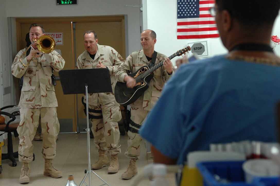 BALAD AIR BASE, Iraq -- Three members of Hot Brass, U.S. Air Forces Central Band, play a tune for staff and patients in the intensive care unit at the Air Force Theater Hospital here, April 8. Working in the intensive care unit can sometimes be taxing on the morale of the staff, but when the musicians rolled in and played a few sets, the room was all smiles. Members of Hot Brass are deployed from Scott Air Force Base, Ill. (U.S. Air Force photo/ Senior Airman Julianne Showalter)