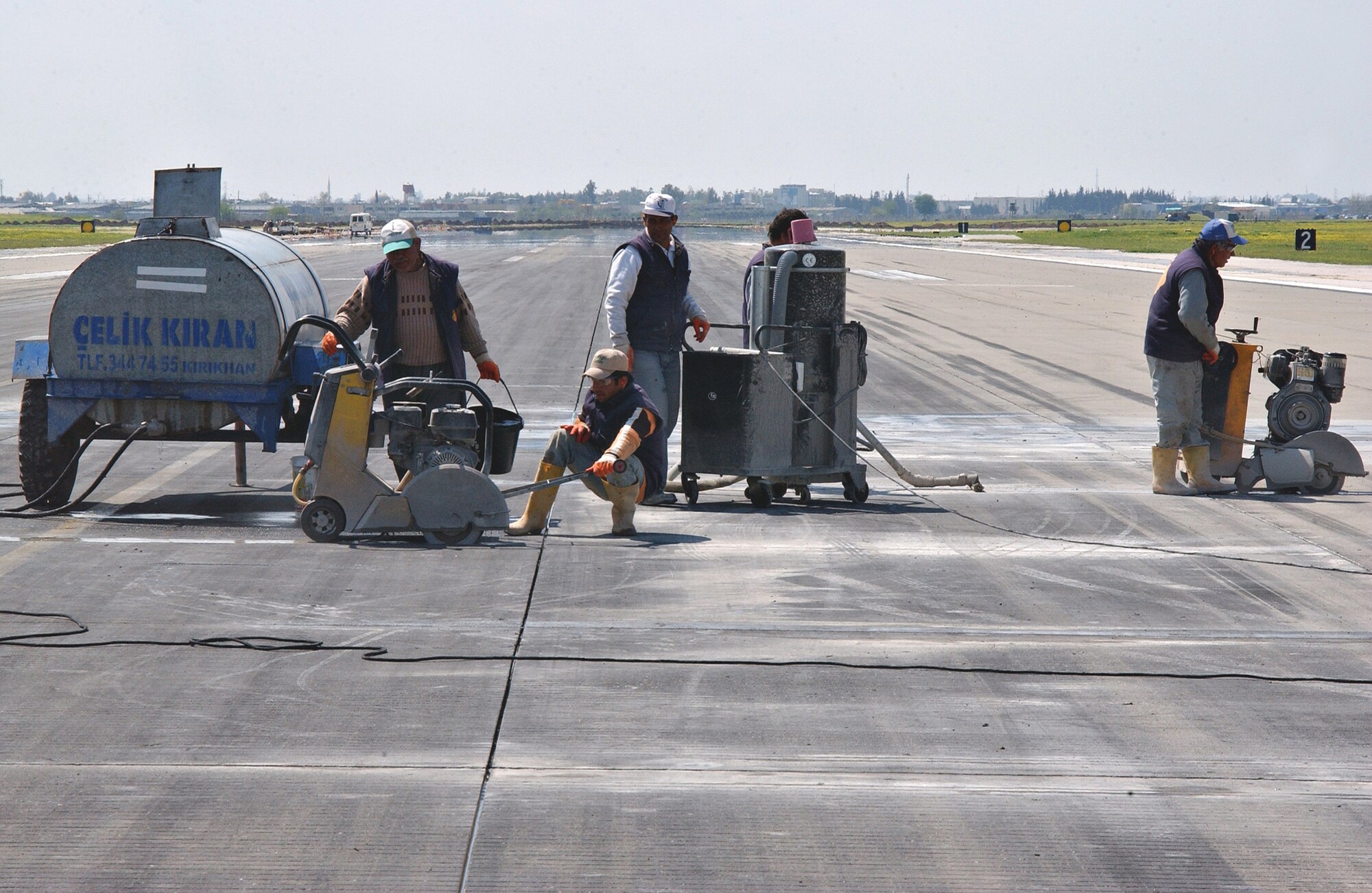 Contractors pour sealant on the Incirlik runway April 2. Sealants add stregnth and increase the life expectancy of the runway. (U.S. Air Force photo by Airman 1st Class Benjamin Wilson)     