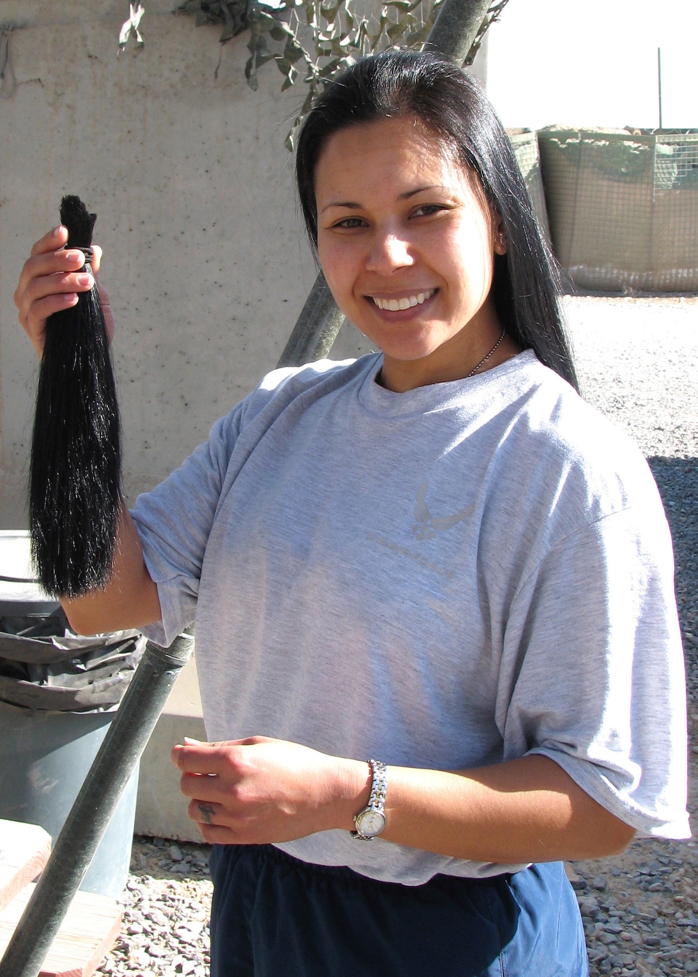 KANDAHAR AIR FIELD, Afghanistan – Staff Sgt. Jenet Akerson, 451st Expeditionary Communications Flight Network Control Center technician, holds 13 inches of her hair she recently cut off to donate to Locks of Love.  Sergeant Akerson is deployed from the 435th Communications Squadron, Ramstein Air Base, Germany.  (U.S. Air Force photo by Staff Sgt. Jeremy Akerson)