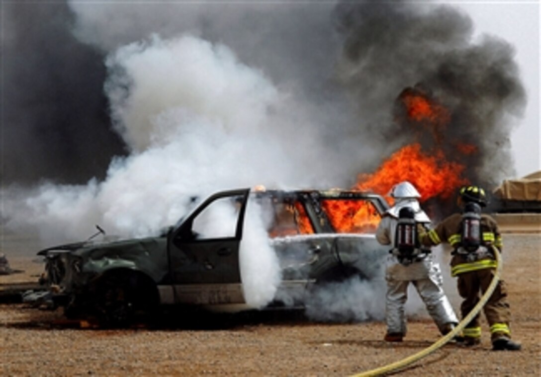 U.S. Air Force firefighters put out a vehicle fire during vehicle extrication training, April 5, 2008, at Balad Air Base, Iraq. The firefighters are with the 332nd Expeditionary Civil Engineer Squadron and 8th Ordnance Company.  