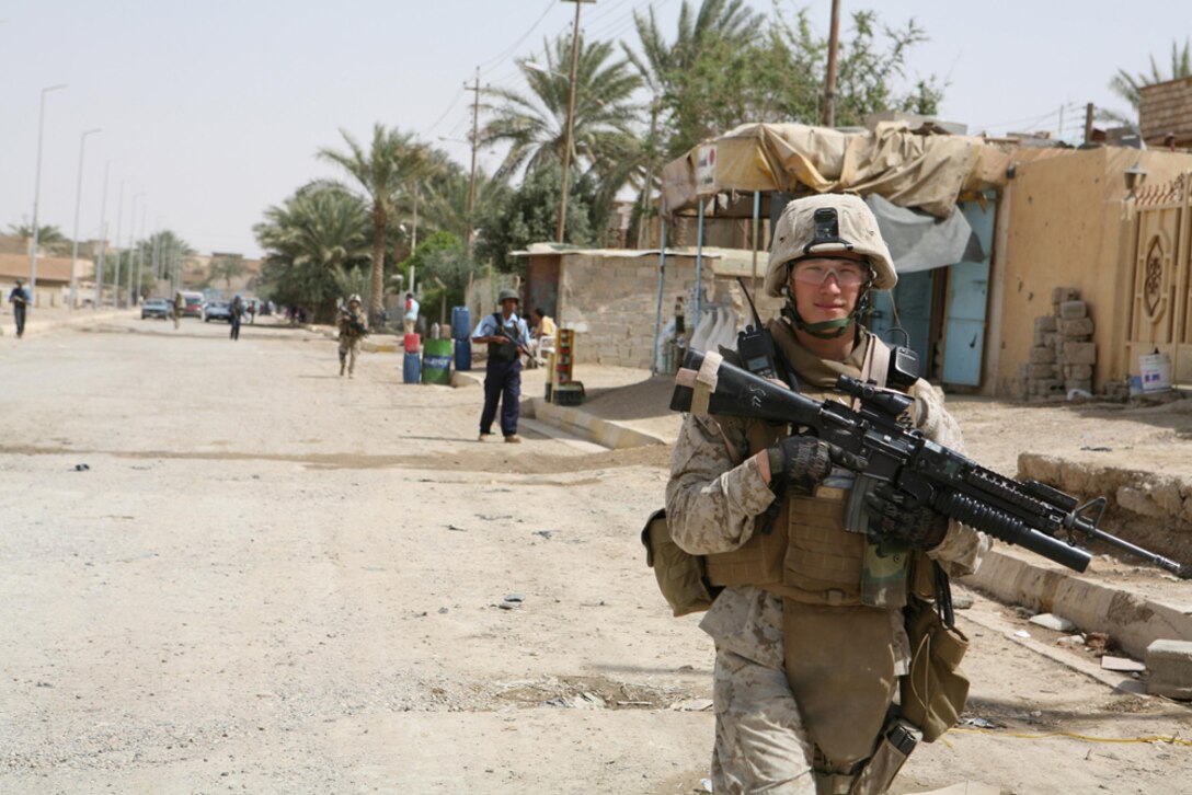 Lance Cpl. Brandon M. Barnes, 21, a team leader with I Company, 3rd Battalion, 4th Marine Regiment, Regimental Combat Team 5, from Fairbanks, Ala., patrols through the city of Hit, Iraq, April 9 with an Iraqi policeman trailing him. Marines with I Company conducted the security patrol with the Iraqi policemen. Despite the language barrier, the Marines and policemen were able to work together.