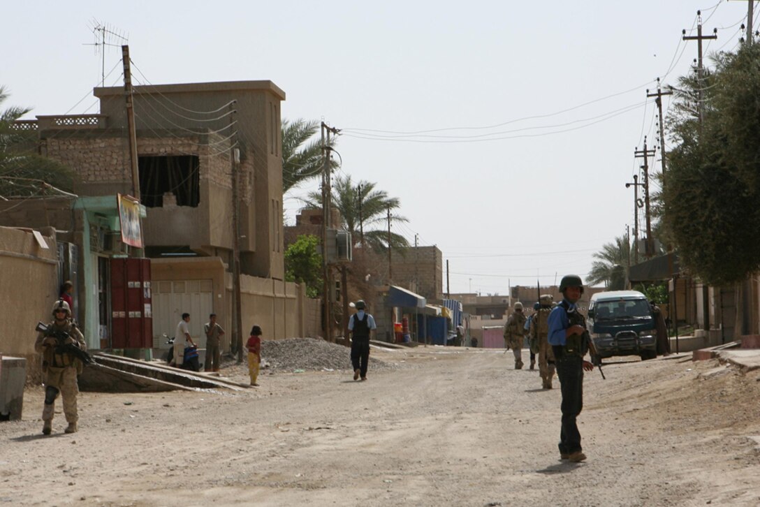 Marines with I Company, 3rd Battalion, 4th Marine Regiment, Regimental Combat Team 5, and Iraqi Policemen patrol through the city of Hit, Iraq, April 9. Marines stopped at an IP station and asked for volunteers to join them during their security patrol. Four men jumped at the opportunity and patrolled through the city with Marines.