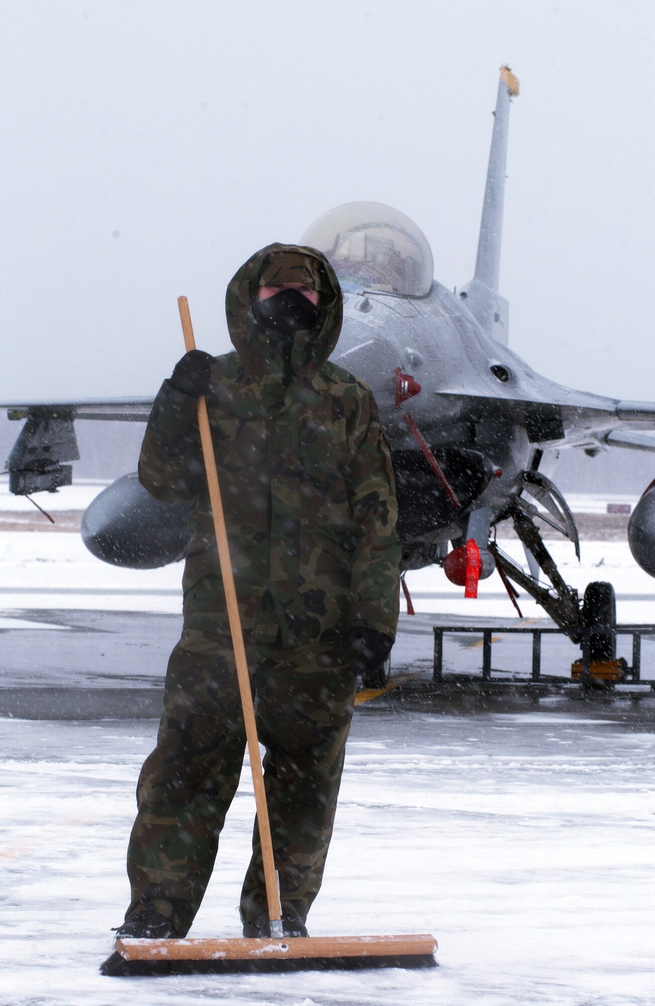 Airman 1st Class Rebecca Cowan along with several others shovel and brush a 15-foot path while snow continues to fall in front of 12 F-16 Fighting Falcons April 10 at Eielson Air Force Base, Alaska. RED FLAG-Alaska 08-2 was hit by a second snow storm grounding the aircrafts while maintainers worked rapidly to remove the continuously falling snow. She is a 35th Aircraft Maintenance Squadron maintainer assigned to Misawa Air Base, Japan. (U.S. Air Force Photo/Airman 1st Class Jonathan Snyder)