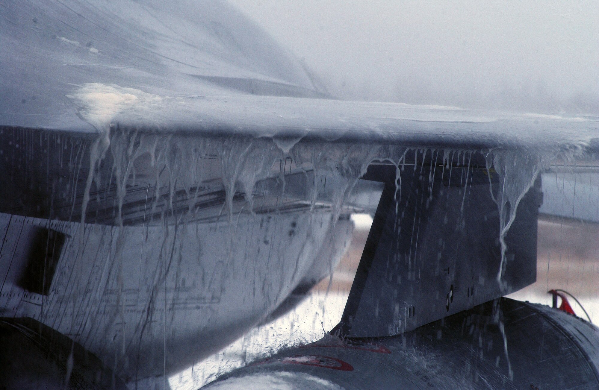 Melted snow and ice from the results of the de-icing chemical runs off the wing of a F-16 Fighting Falcon April 10 at Eielson Air Force Base, Alaska. RED FLAG-Alaska 08-2 was hit by a second snow storm grounding the aircrafts while maintainers worked rapidly to remove the continuously falling snow. (U.S. Air Force Photo/Airman 1st Class Jonathan Snyder)