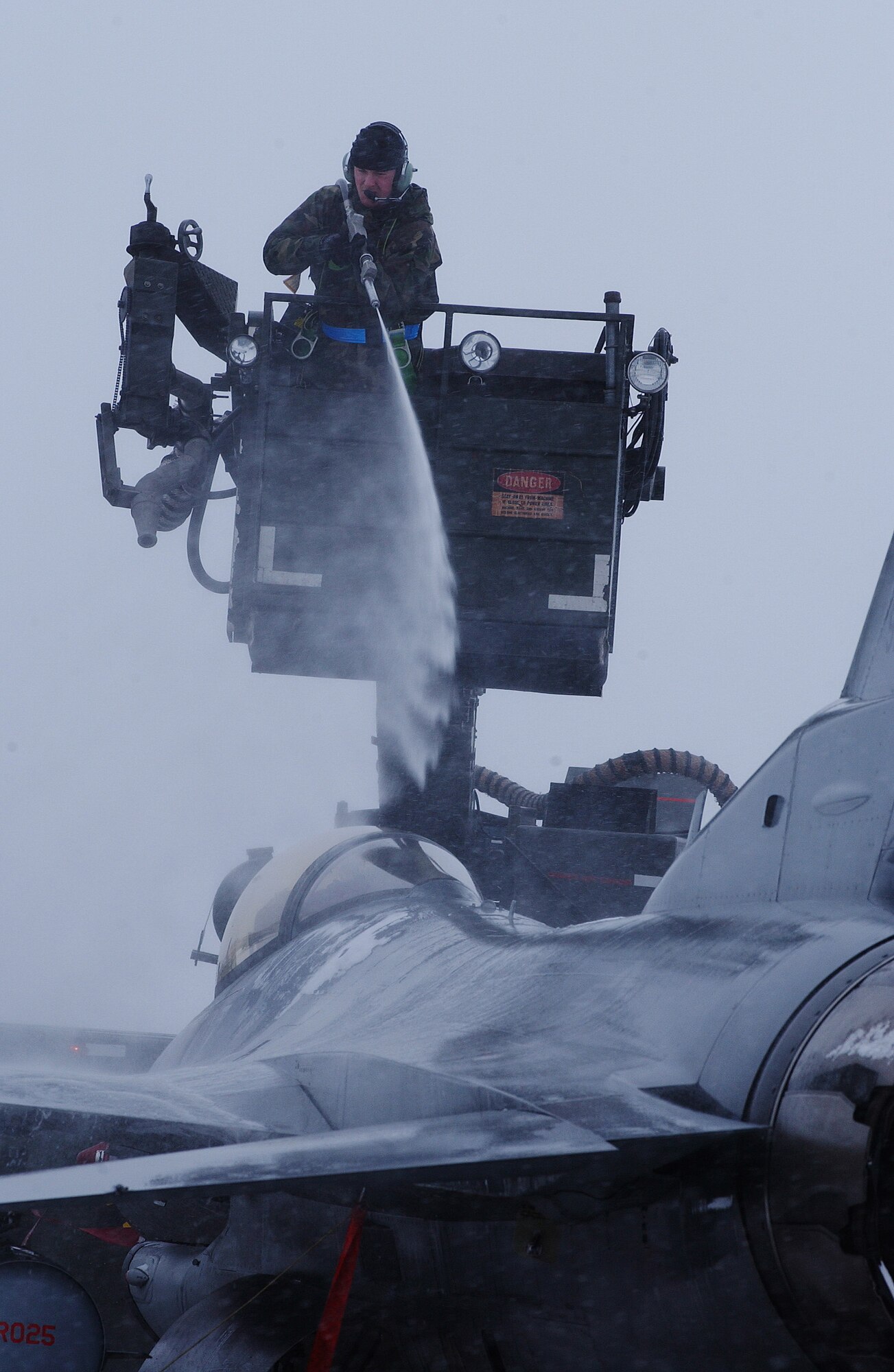 Airman 1st Class Danny Reynolds sprays de-icing chemical onto a F-16 Fighting Falcon, which melts ice and snow accumulated on the aircraft April 10 at Eielson Air Force Base, Alaska. RED FLAG-Alaska 08-2 was hit by a second snow storm grounding the aircrafts while maintainers worked rapidly to remove the continuously falling snow. He is assigned to the 35th Aircraft Maintenance Squadron at Misawa Air Base, Japan. (U.S. Air Force Photo/Airman 1st Class Jonathan Snyder)
