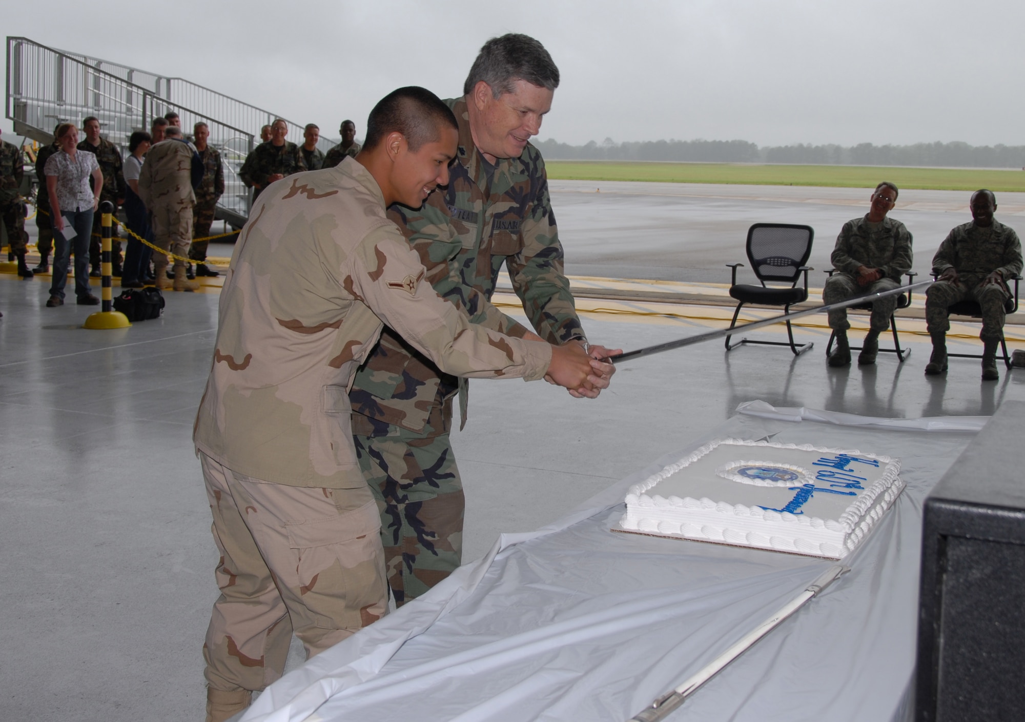 To recognize where the Air Force Reserve has come from and where they're going, the oldest and youngest member of the 908th Airlift Wing, Lt. Col. Carl Poteat and Airman Tony Dinofrio, cut a cake with the seal of the Air Force Reserve Command painted in icing at Maxwell AFB, Ala., April 5. Along with celebrating the Air Force Reserve's diamond anniversary, the Montgomery, Ala.-based 908th AW honored Hank Williams by changing the unit's C-130 cargo planes' radio call sign to "Hank" and painting "Ramblin' Man" over the door of one of the aircraft.  (U.S. Air Force photo by Mr. Jeff Melvin)