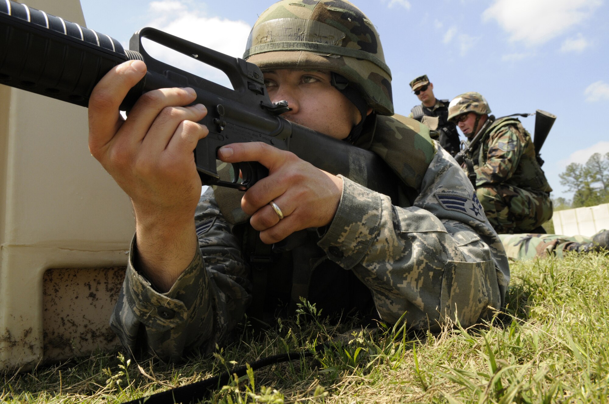 SrA Joshua Jones covers the area after members of his team pull an injured "victim" to safety behind a barrier during an Air and Space Expeditionary Force Deployment Preparation training course scenario April 8 at Gator Air Base. U. S. Air Force photo by Sue Sapp