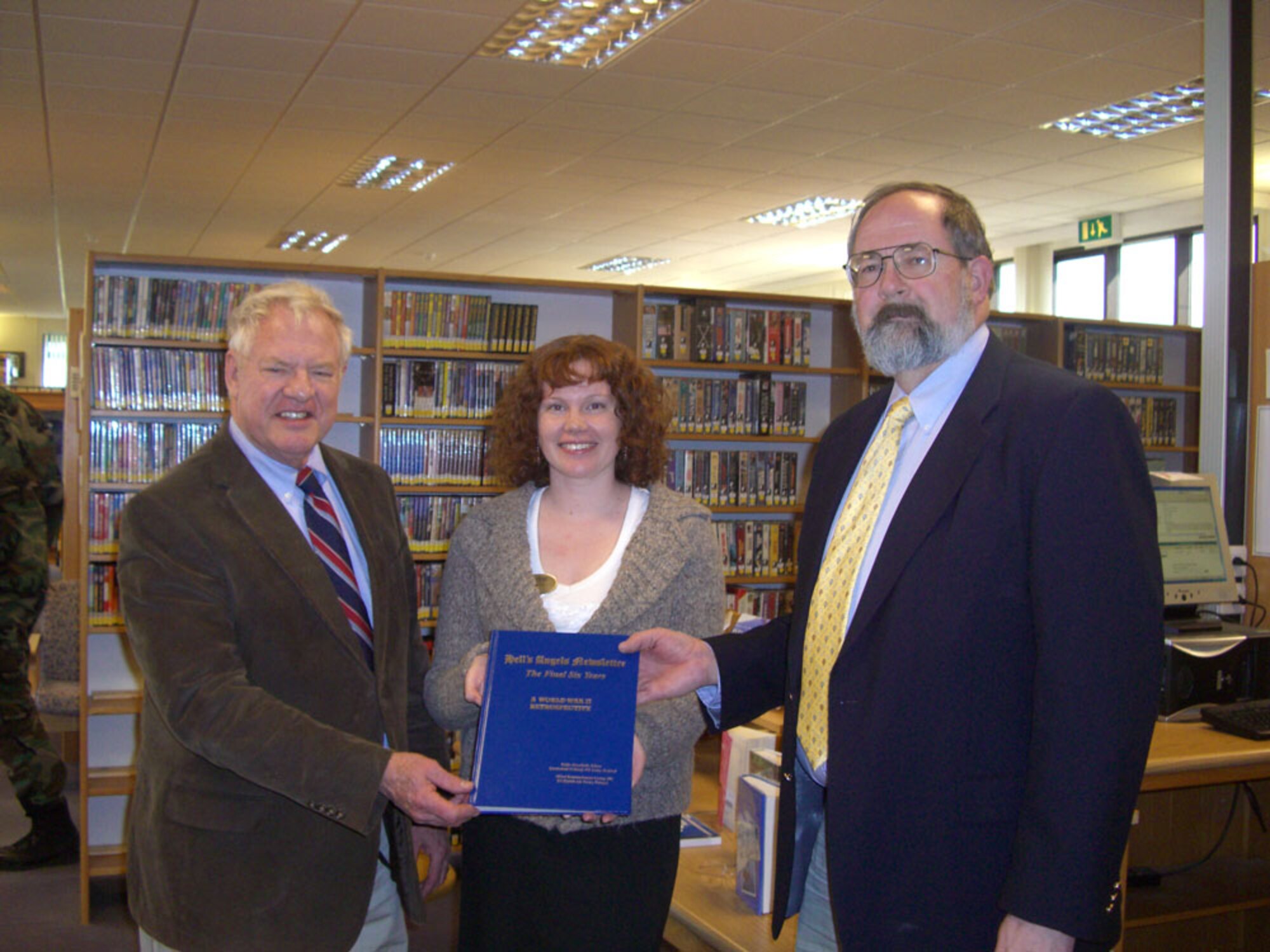 Ms. Annette Short of the Royal Air Force Alconbury Base Library accepts the donation of "Hells's Angels Newsletter; The Final Six Years - A World War II Retrospective" from the 303rd Bomb Group (Heavy) Association.  With Ms. Short is Mr. Peter G. Park, JAC Historian and Mr. Jerry White, 501st CSW Historian. (U.S. Air Force Photo by Peter Park)