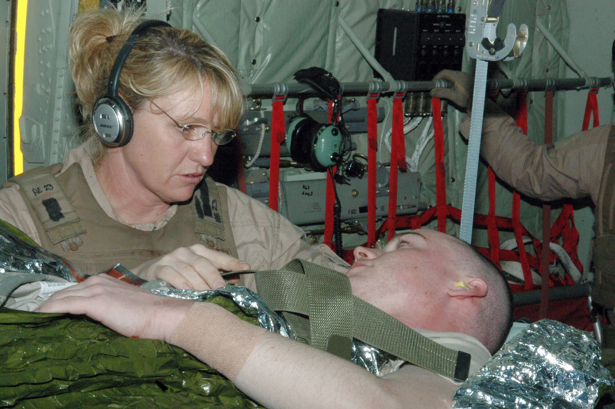Capt. Lisa Causey cares for a litter patient on board a C-130 Hercules April 2 in Southwest Asia. She and four other medics and the C-130 aircrew made a 15-hour flight to four cities in Iraq and one air base in the Middle East. They airlifted 19 patients, 16 of whom were ambulatory, to the Persian Gulf, where most of the patients were transferred to a C-17 Globemaster III headed for Germany. Captain Causey is a 379th Expeditionary Aeromedical Evacuation Squadron second flight nurse. She is an Air National Guard member deployed from the 183rd Aeromedical Evacuation Squadron from Jackson, Miss. (U.S. Air Force photo/Senior Airman Carolyn Viss) 